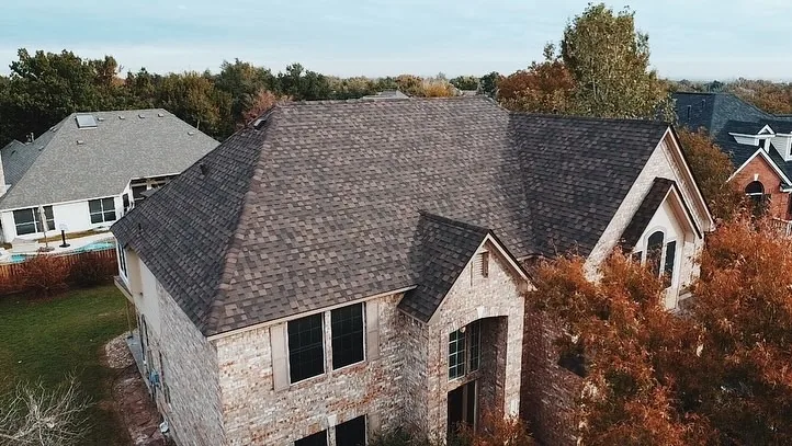 New architectural shingle roof on a brick two-story home, aerial view