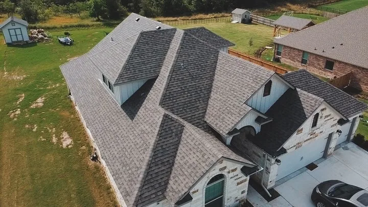 Completed grey shingle roof on a Liberty Hill acreage home, aerial view