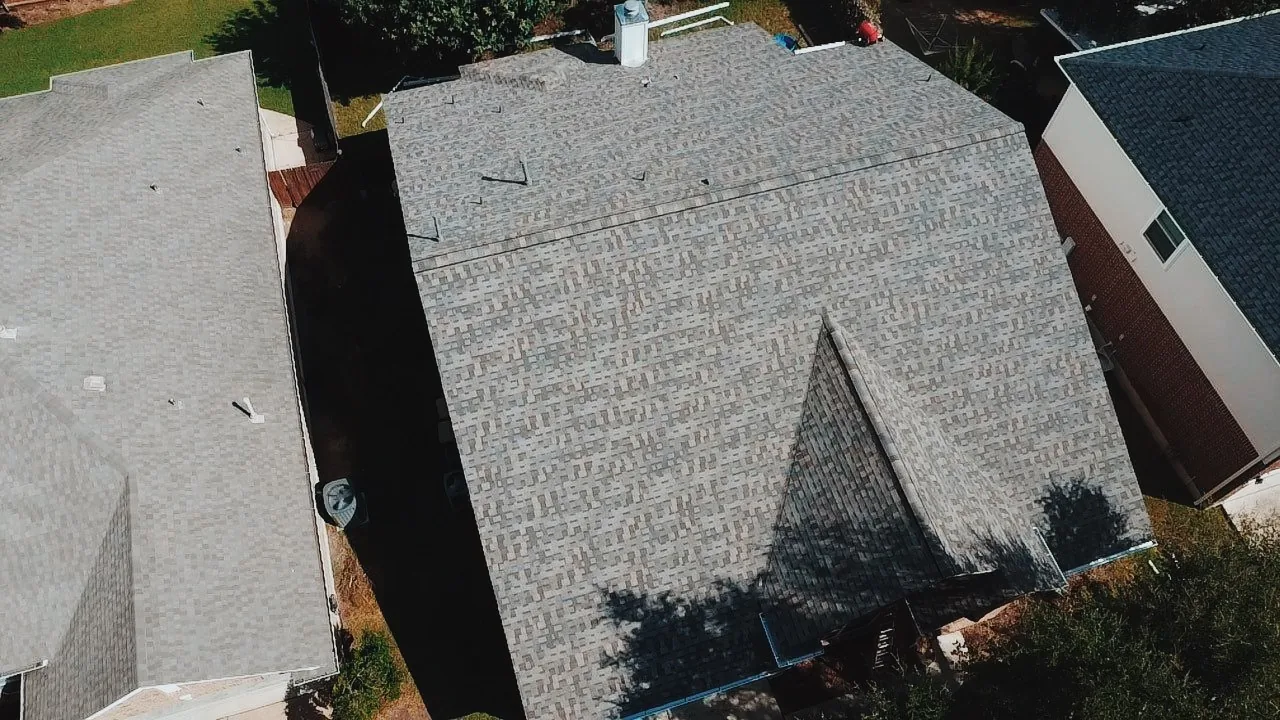 Aerial view of completed grey shingle roof installed by Urtiz Roofing on suburban home
