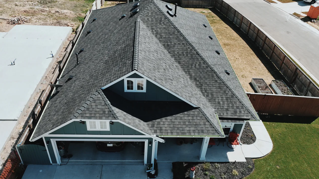 Aerial view of completed dark shingle roof installed by Urtiz Roofing on Texas home