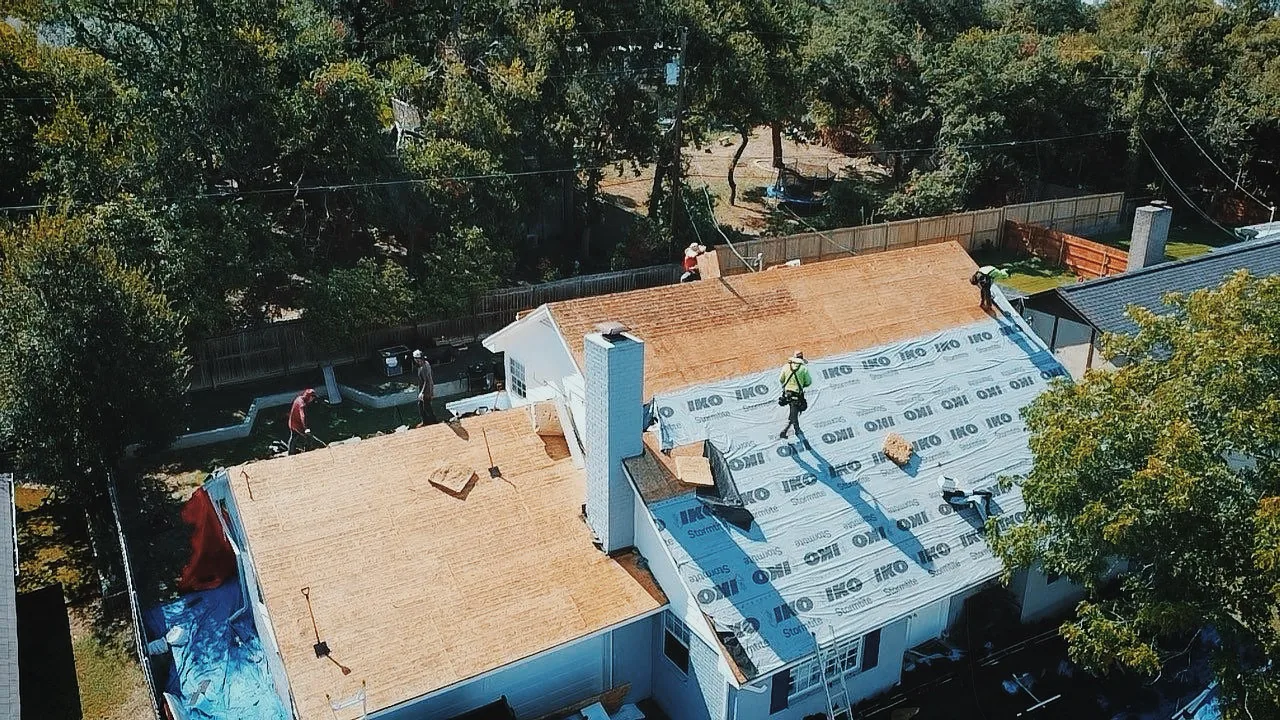 Urtiz Roofing crew mid-replacement with IKO materials staged on the roof