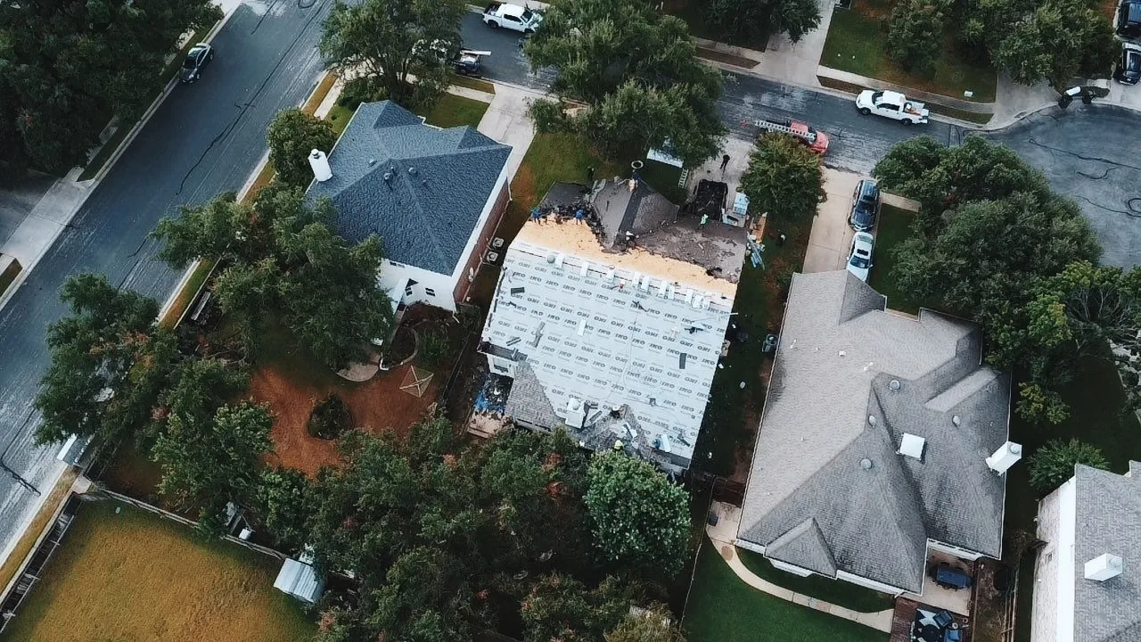 Aerial view of a roof replacement in progress with new materials