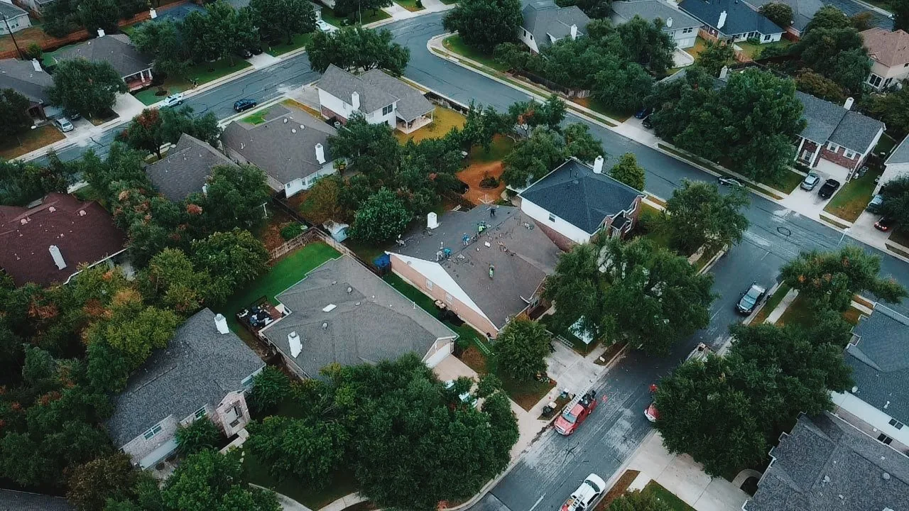 Aerial view of storm restoration roofing work across a neighborhood