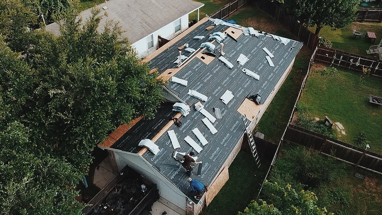 Aerial view of Urtiz crew working on a roof replacement with underlayment visible